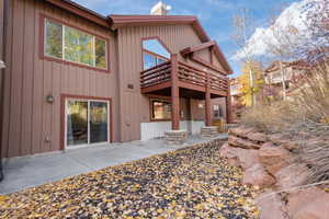 Back of house with a patio, a chimney, and board and batten siding