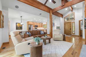 Living area featuring recessed lighting, light wood-style floors, beamed ceiling, a ceiling fan, and high vaulted ceiling