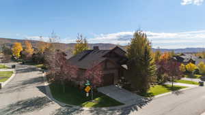 View of front of property featuring a mountain view, driveway, and roof mounted solar panels
