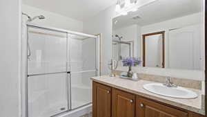 Bathroom with a shower stall and vanity