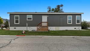 Manufactured / mobile home with a front lawn and crawl space