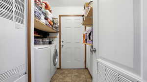 Laundry area featuring a heating unit, dark tile patterned floors, and washer and dryer