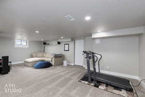 Workout area featuring a textured ceiling, carpet flooring, and recessed lighting