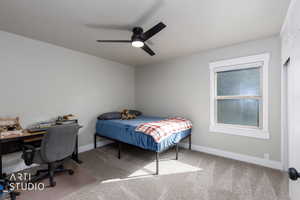 Bedroom featuring carpet, a desk, and a ceiling fan