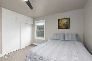 Bedroom featuring light colored carpet, ceiling fan, and a closet