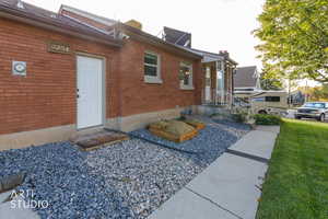 View of front facade with brick siding, a front lawn, and a chimney