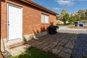 View of property exterior with brick siding, a patio area, and entry steps