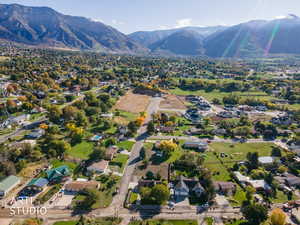 Aerial view of property and surrounding area with a mountainous background and nearby suburban area