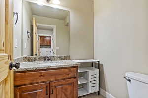 Half bath with vanity and light tile patterned flooring