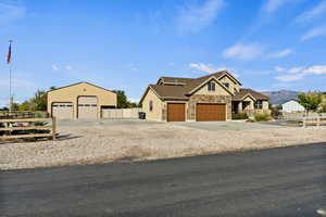 Craftsman house with stone siding, a mountain view, an outdoor structure, driveway, and a detached garage
