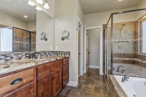 Full bath with vanity, a bath, a stall shower, backsplash, and recessed lighting