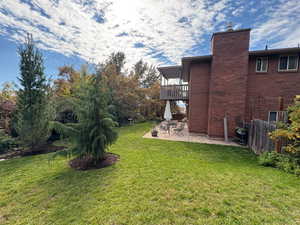 View of green lawn with a patio area