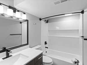 Bathroom with bathtub / shower combination, vanity, and a textured ceiling