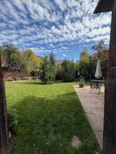View of green lawn with a patio area