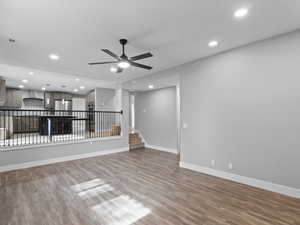Unfurnished living room with recessed lighting, a ceiling fan, wood finished floors, and stairway