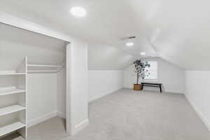 Bonus room featuring light colored carpet and lofted ceiling