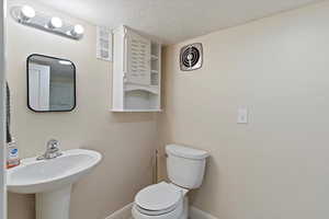 Bathroom with toilet and a textured ceiling