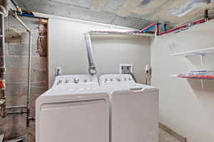 Washroom with washer and dryer and baseboards