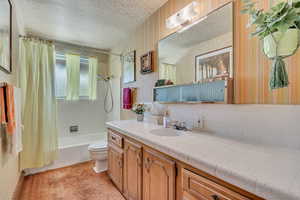 Hall bathroom featuring wallpapered walls & ceiling, shower / bath combination with curtain.