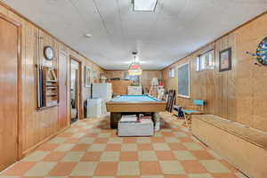 Rec room featuring wooden walls, billiards, and tile patterned floors