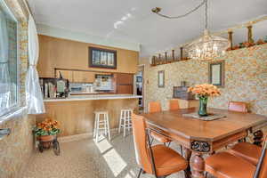 Dining space with wallpapered walls and a chandelier