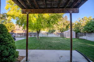 Fenced backyard with a pergola, a shed, and a patio area