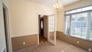 Unfurnished bedroom with carpet flooring and a chandelier