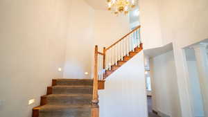 Stairway featuring a high ceiling and a chandelier