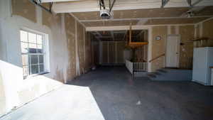 Garage featuring freestanding refrigerator and a garage door opener