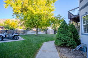 Fenced backyard featuring a storage unit