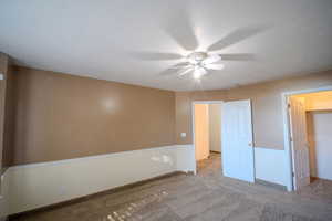 Unfurnished bedroom with carpet, ceiling fan, and a textured ceiling