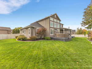 Back of property featuring a fenced backyard, a wooden deck, and stucco siding