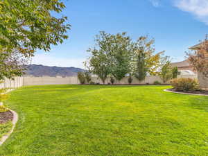 Fenced backyard featuring a mountain view
