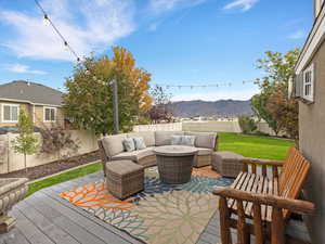 Deck featuring a mountain view, a fenced backyard, and an outdoor living space