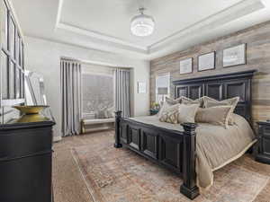 Bedroom featuring a tray ceiling and light carpet