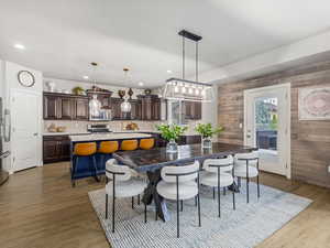 Dining room featuring dark wood-type flooring, wooden walls, and recessed lighting
