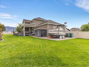 Back of property featuring a fenced backyard, stucco siding, a jacuzzi, and a deck with mountain view