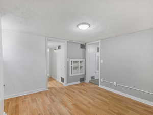 Spare room featuring a textured ceiling and light wood-style floors