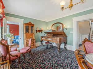Living area featuring crown molding and stairs