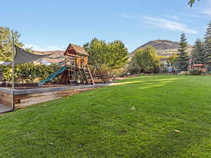 View of jungle gym with a lawn and a mountain view