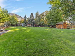 View of grassy yard featuring an outdoor structure