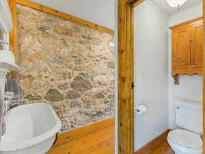 Bathroom with hardwood / wood-style flooring and toilet