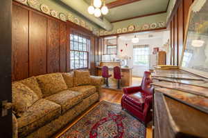 Living area featuring rich wood paneling, wood-finish flooring, and a unique breakfast bar with built-in seating