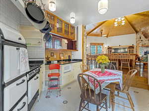 Kitchen with open shelves, healthy amount of natural light, tasteful backsplash, dark countertops, and wooden ceiling