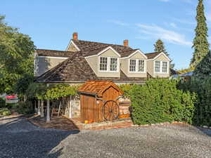 View of front of house featuring a chimney and a storage unit