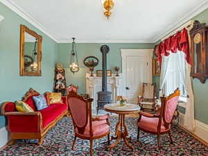 Living area with a wood stove and ornamental molding