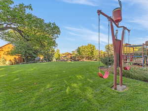 View of green lawn featuring a playground