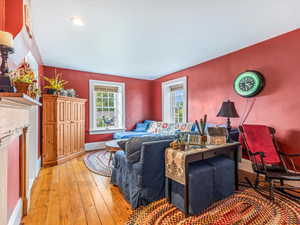 Living room with light wood finished floors, a fireplace, and recessed lighting