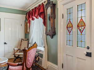 Doorway with healthy amount of natural light and ornamental molding