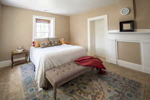 Carpeted room featuring a white-trimmed window, paneled wall molding, and a solid wood door